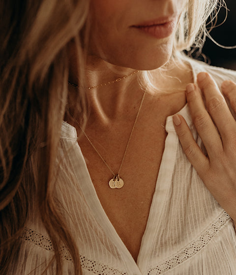 woman wearing circle initial necklaces with choker necklace
