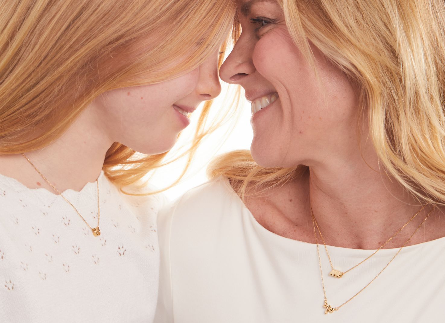 daughter and mother embracing wearing tiny tags target necklaces