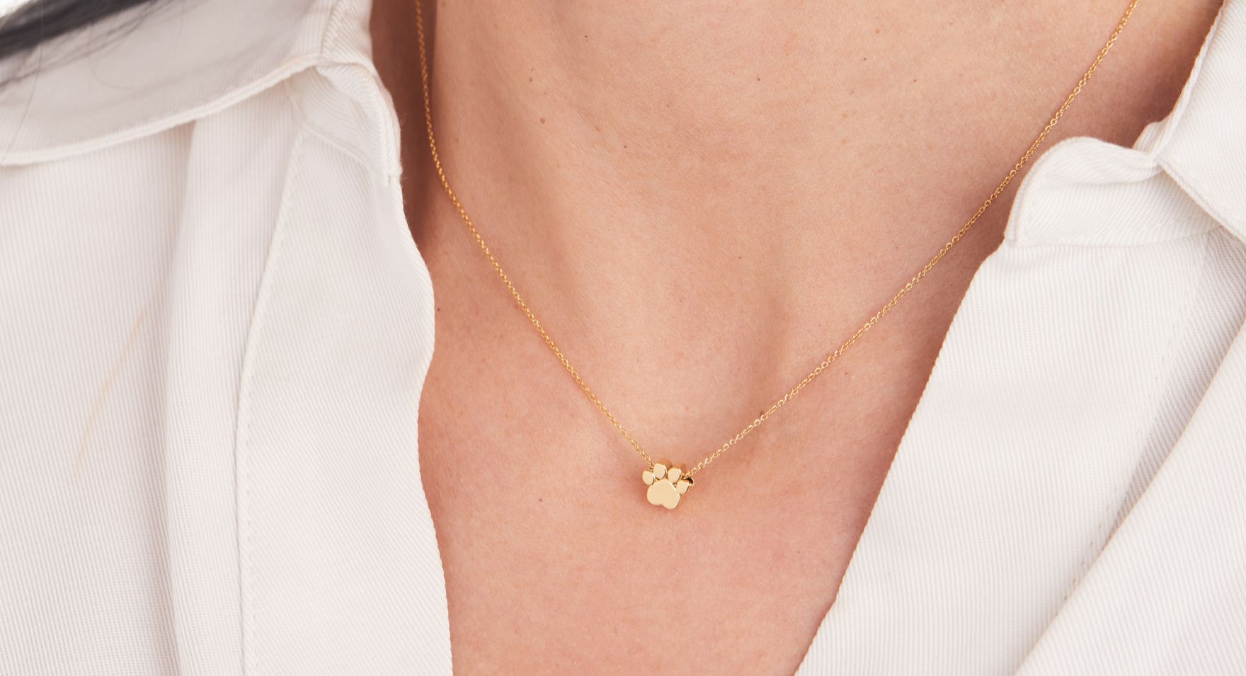 woman wearing pawprint tiny tags necklace