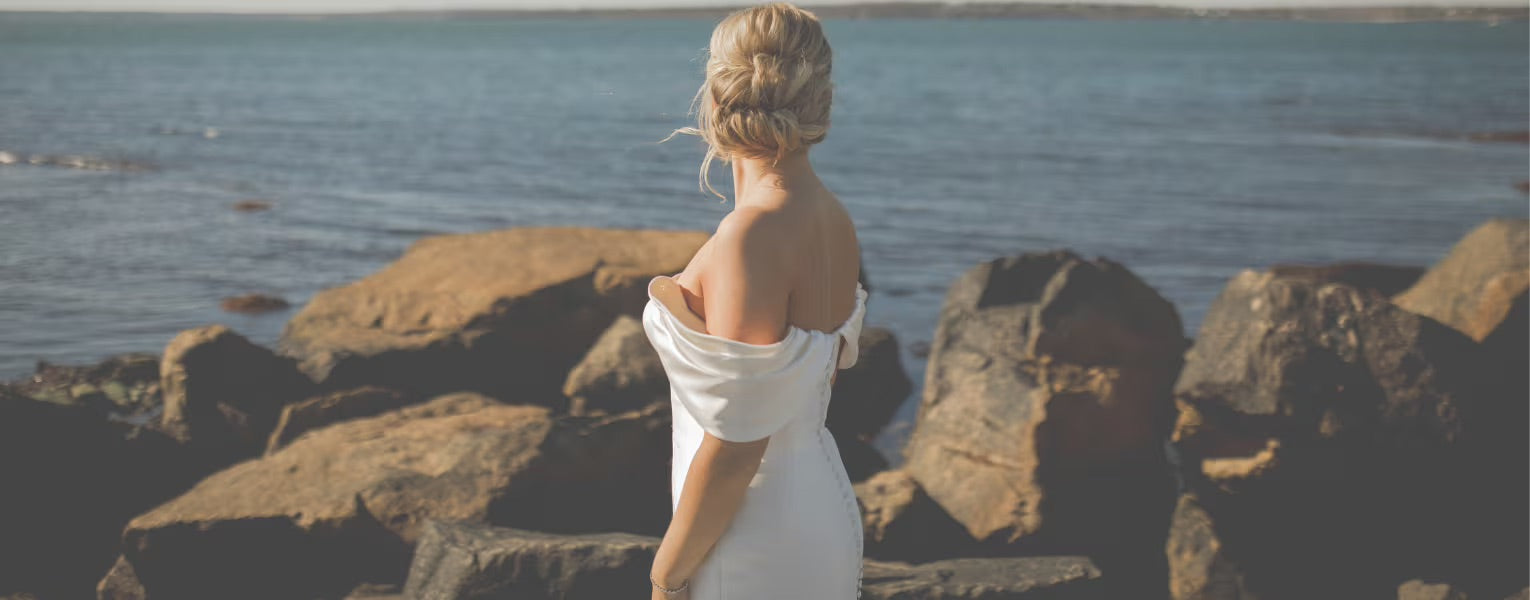 woman in wedding dress looking at ocean