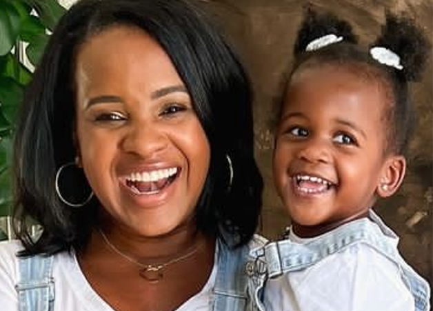 taryn newton wearing circle pendant necklace holding her daughter