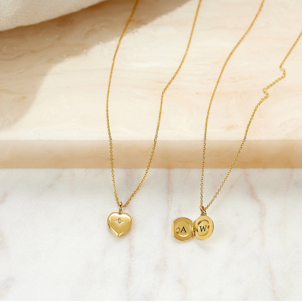 Heart and round mini locket necklaces on marble background