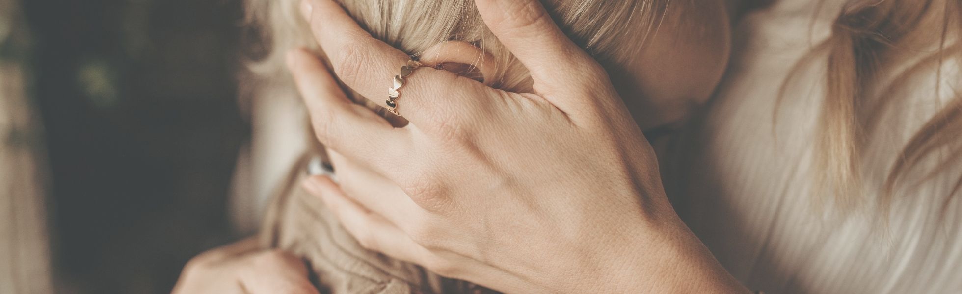 mom and son hugging with mom wearing tiny tags jewelry